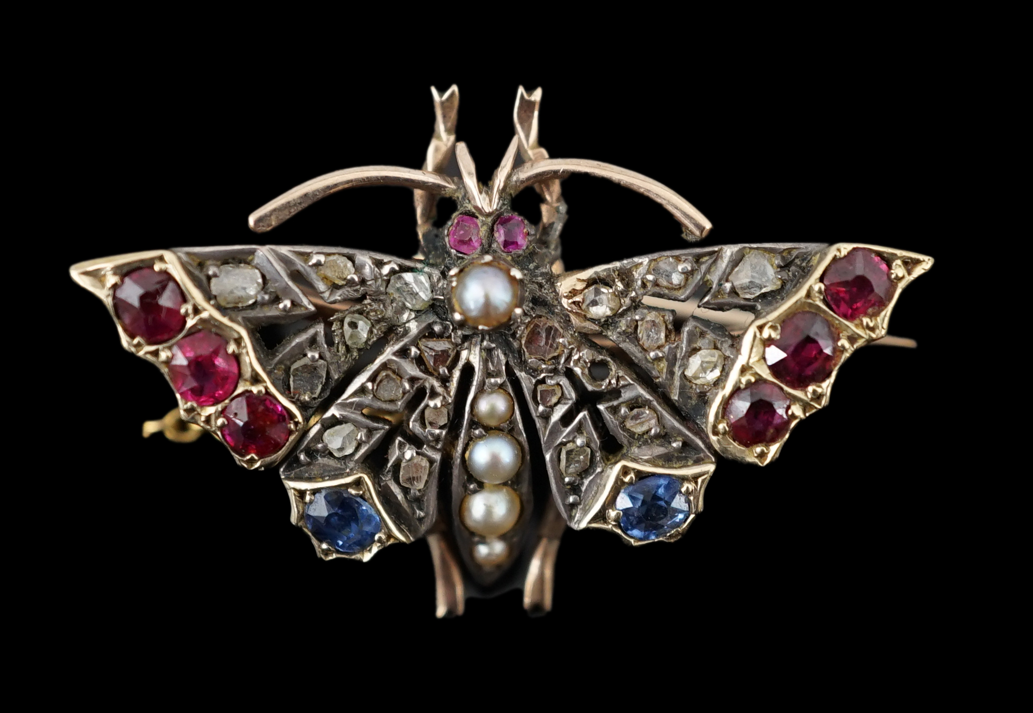 A Victorian gold, ruby, sapphire, split pearl and diamond cluster set butterfly brooch